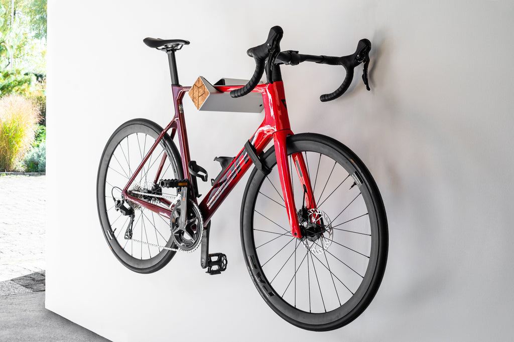 Rotes Fahrrad hängt auf silberner Fahrrad-Wandhalterung